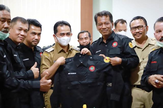 Ketua PKPS Prov. Riau, Jhon Satri, menyerahkan seragam PKPS Riau.